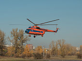 An emergency helicopter is taking off from city helicopter's pad.