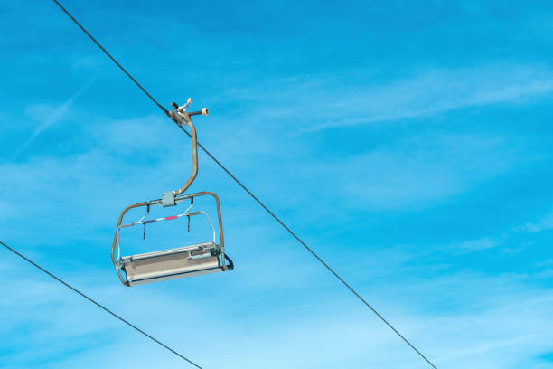 Empty ski chair lift in winter resort against blue sky