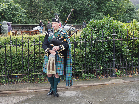 Edinburgh, UK - September 15, 2023: Bagpipe player busking on Waverley Bridge