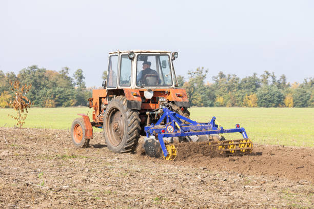 The tractor uses discs to plow the soil after harvesting in the autumn.