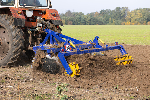The tractor uses discs to plow the soil after harvesting in the autumn.