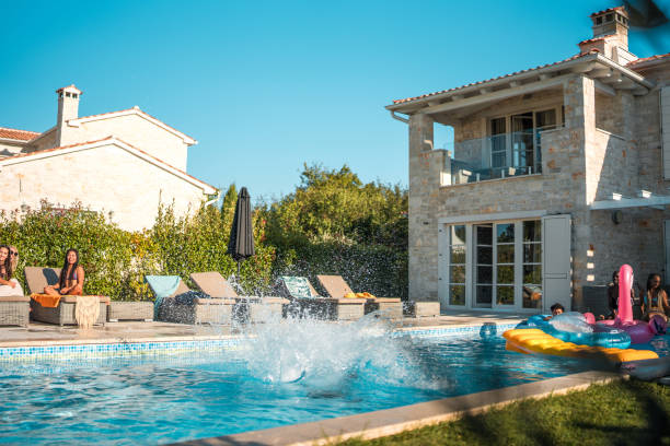 istock Diverse Friends Enjoy Cannonball Splash at Luxury Villa 1751652085