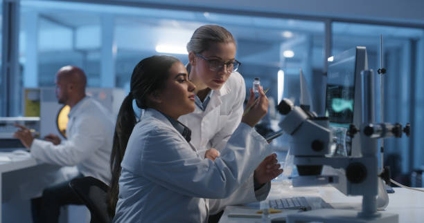 istock Science, microscope or sample with a doctor and student in a laboratory for research or medicine. Collaboration, technology or experiment with a scientist and young intern in a lab for development 1751659707
