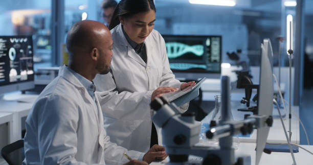 istock Scientist, teamwork and tablet or computer for laboratory advice, research feedback and medical results at night. Mentor, doctors or science people talk of molecule or DNA test on digital technology 1751659727