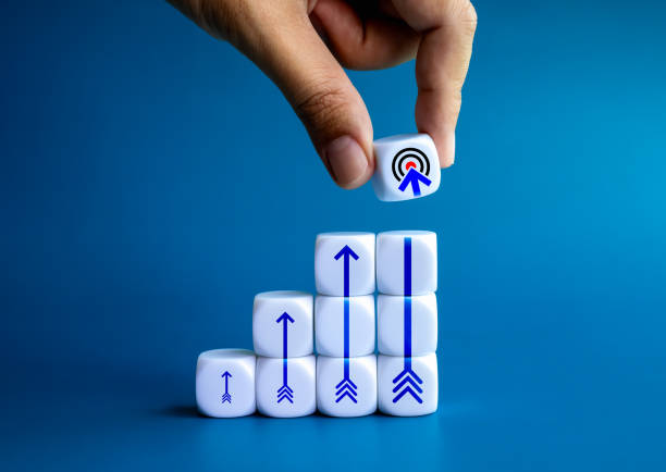 istock Target icon hold by businessman hand, put on top of white cube block stack as growth graph steps with rising up arrow icons on blue background. Goal and success, objective and business plan concepts. 1751674186