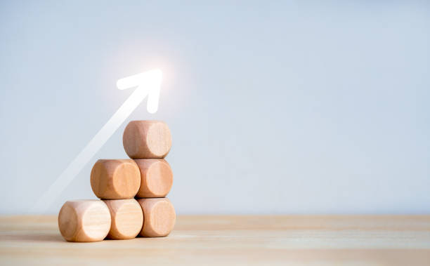 istock Rise up glowing arrow on wooden cube blocks as a business chart steps isolated on white background with copy space. Business growth graph process, goal, success, and economic improvement concepts. 1751674198