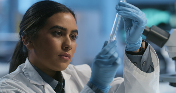 Test tube, scientist face and woman study liquid, biotech or pharmaceutical product investigation. Lab, chemical engineering industry or expert working on medicine process, innovation or experiment