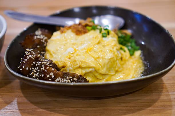 Side view of pork belly rice and omelet on the dining table.