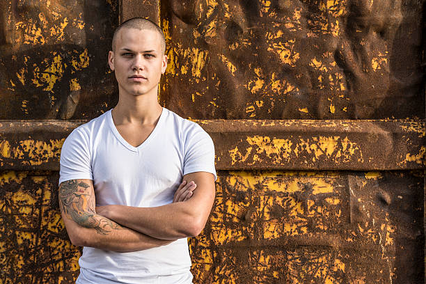 istock pensive young man with arms crossed 175169111