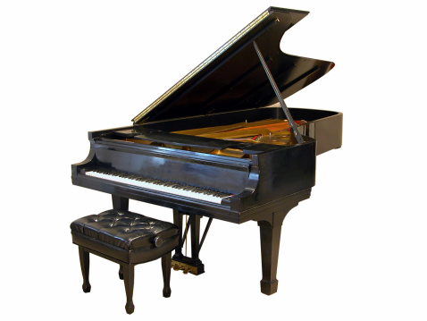 Old grand piano on a smoky stage lit by a single spotlight