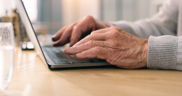 istock Desk, senior and hands typing on laptop at home on internet research, remote work and email. Closeup, elderly person and keyboard at table, computer and pc technology for communication in retirement 1751706206