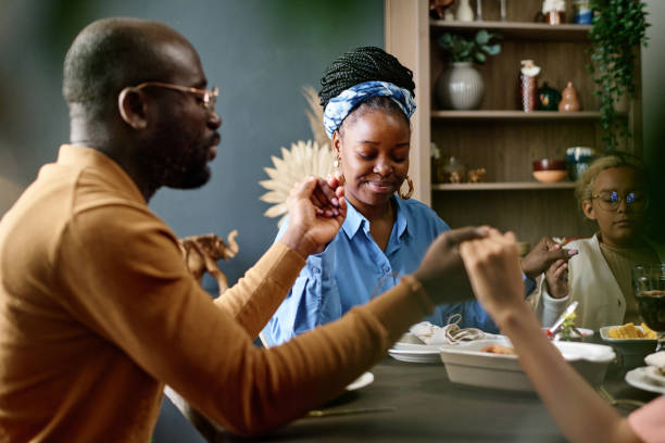 istock Happy young woman sitting between her husband and daughter by table 1751711778