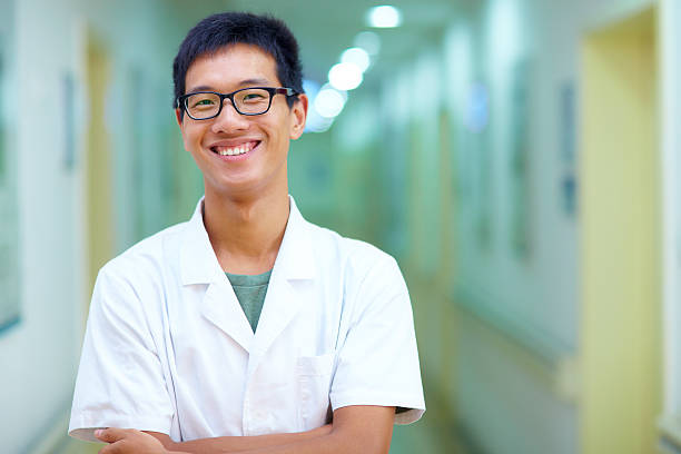 retrato de jovem do sexo masculino médico a sorrir para a câmara - doctor wom imagens e fotografias de stock