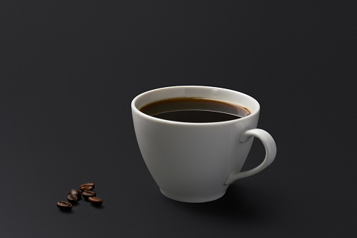 Black coffee and coffee beans on black background