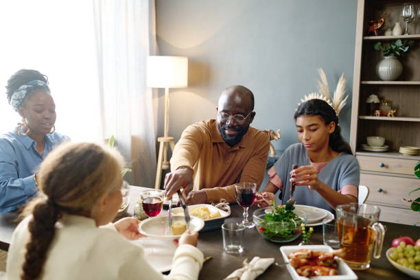 istock Young man putting corn on plate of his daughter over served festive table 1751718580