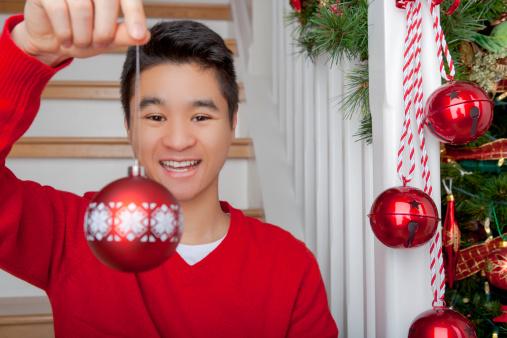 Happy asian man holding red bauble