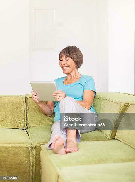 Sonriente Mujer Senior Con Ordenador Foto de stock y más banco de imágenes de 60-69 años - 60-69 años, Adulto, Agarrar