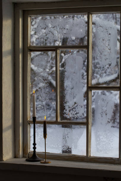 istock old window with winter landscape and burning candles on windowsill 1751725305