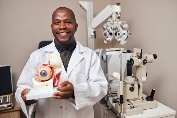 istock Ophthalmologist, care and 3d eye model for learning, teaching and education for vision, wellness and help. African optometrist, exam or test with health, smile and healthcare for eyesight in clinic 1751725937