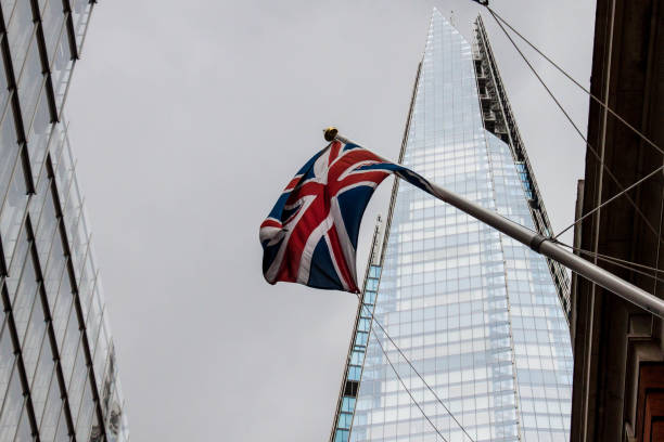 bandera británica ondeando frente a the shard durante un día nublado - london england thames river storm rain fotografías e imágenes de stock