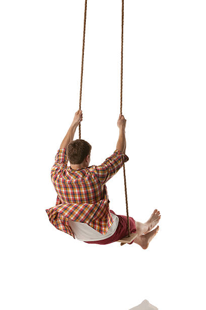 istock Rear view of a man swinging on rope swing 175174196