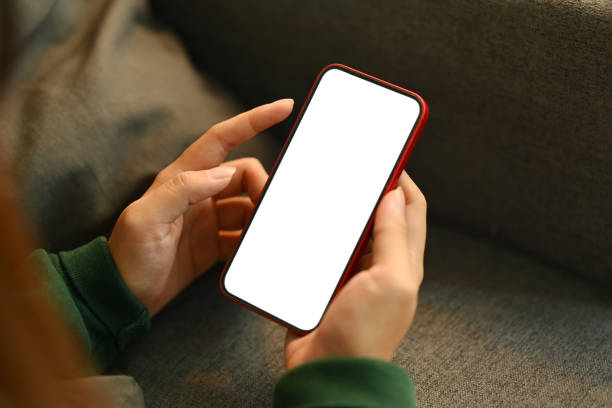 istock Close up shot woman holding smartphone with white screen while lying on couch 1751748777