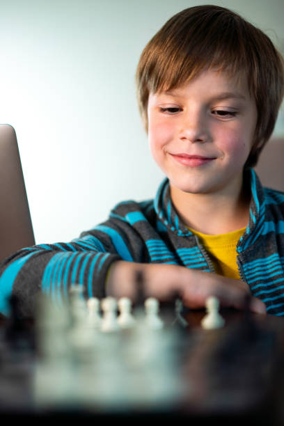 niño jugando al ajedrez - chess skill concentration intelligence fotografías e imágenes de stock