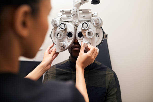 Optometrist, patient and phoropter in clinic, help or lens for check, eye exam or healthcare for wellness. Ophthalmologist, person and machine to test eyesight, care or vision for results in hospital optometrista, paciente y foróptero en clínica, ayuda o lente para chequeo, examen ocular o atención médica para el bienestar. oftalmólogo, persona y máquina para evaluar la vista, el cuidado o la visión para obtener resultados en el hospital