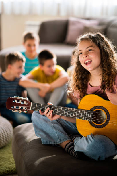 istock Girl playing guitar while her friends talking in background 1751752161