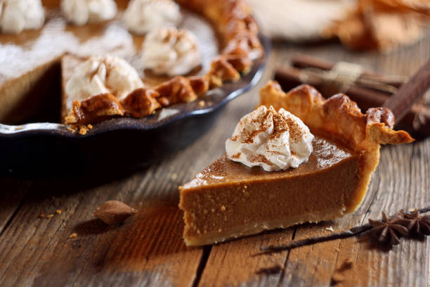 istock Pumpkin pie with whipped cream and cinnamon on wooden background 1751755011