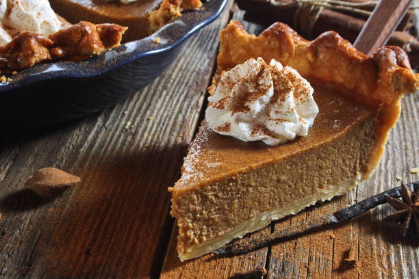 istock Pumpkin pie with whipped cream and cinnamon on wooden background 1751755012