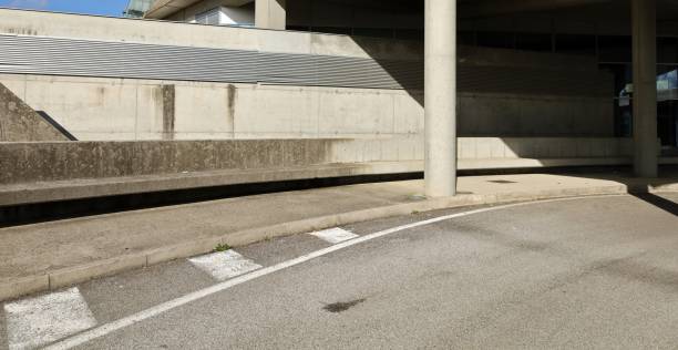 istock Exit of a road underpass with large columns on  sidewalk and concrete block wall on behind. 1751755547