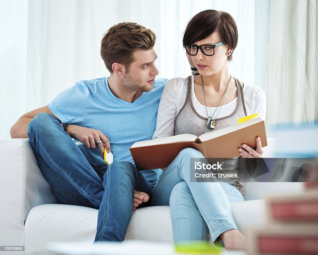 Young couple learning at home Young couple sitting on sofa at home and learning together. 20-24 Years Stock Photo