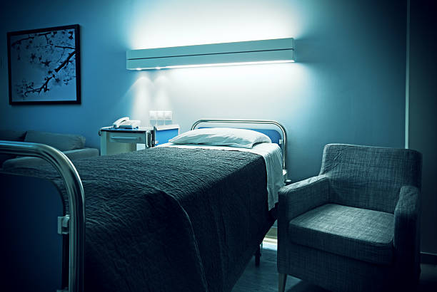 Hospital bed and visitor armchair Empty hospital room with bed and visitor armchair. Poster on the wall is from my own pictures. night hospital bed stock pictures, royalty-free photos & images