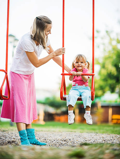 istock Mother and her cute daughter enjoying outdoors on a swing. 175176300