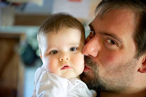 istock Dad kissing baby 175176429