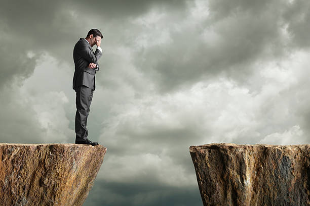 istock Distraught businessman standing at the edge of a cliff 175176562