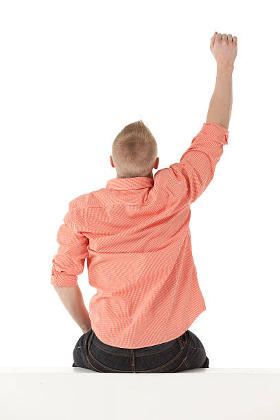 Man sitting on the ledge of a wall