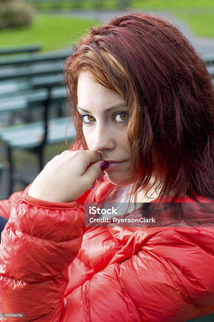 Beautiful Woman in the Rain. A beautiful woman in Halifax Nova Scotia, Canada, sits on a park bench with red hair streaming down  in the rain. 20-29 Years Stock Photo