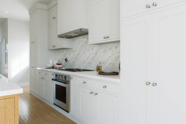 istock Kitchen with white cabinets, kitchen appliances and wood floors. Kitchen wall with dishes. 3D rendering 1751769868