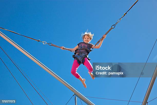 Mädchen In Der Luft Schwebend In Gurt Auf Bungeekarnevalride Amusement Park Stockfoto und mehr Bilder von Bungeejumping