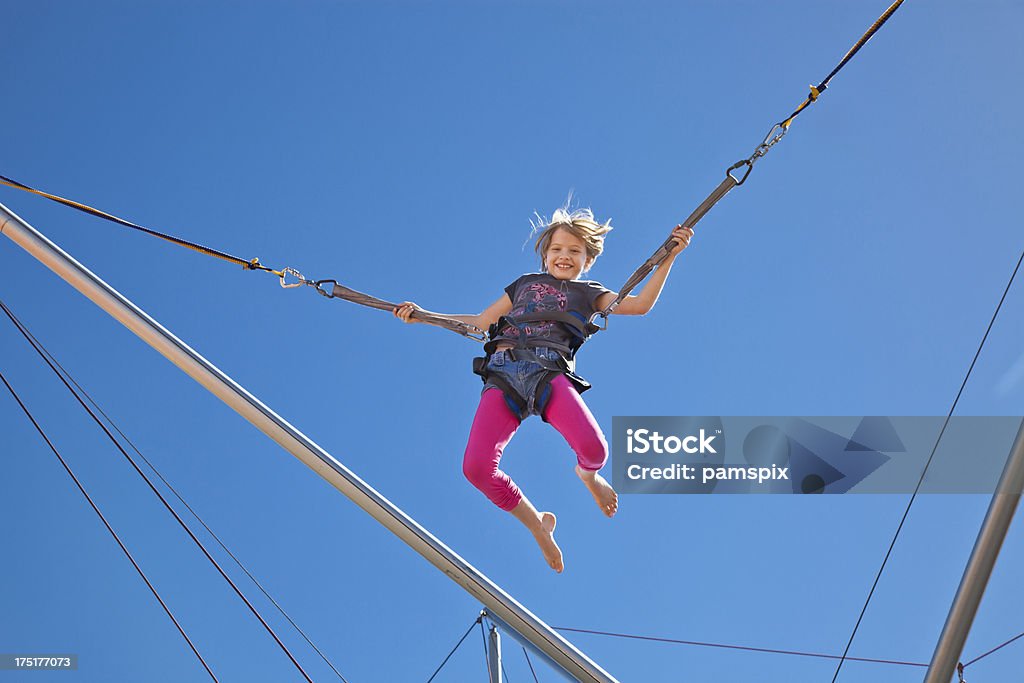 Fille en l'Air dans le harnais le carnaval de saut à l'élastique en Parc d'attractions - Photo de Saut à l'élastique libre de droits