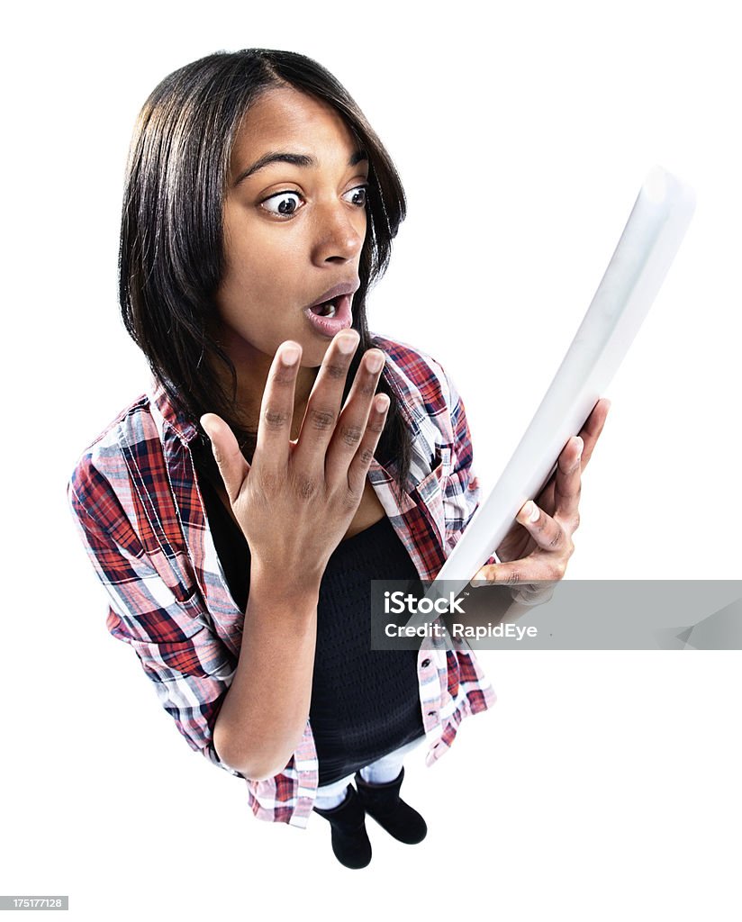 Looking down at cute teenager shocked by digital tablet image "Exaggerated high-angle view of a pretty young girl, her hand to her mouth, looking shocked by what she sees on the touch screen of her tablet-style computer. Isolated on white." 20-29 Years Stock Photo