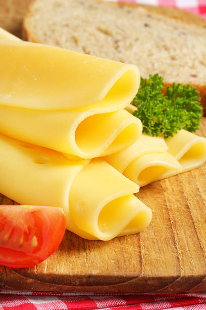 rodajas de queso en una tabla de cortar - yellow cheese thin portion fotografías e imágenes de stock