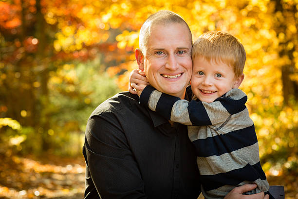 istock Happy Father and Son Hugging in Colorful Autumn Woods 175178255