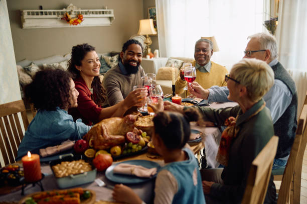 istock Happy multigeneration family toasting while celebrating Thanksgiving at dining table. 1751783014