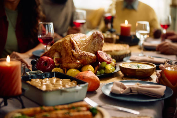 istock Thanksgiving turkey with family gathered at dining table. 1751783015