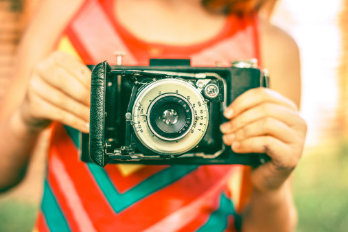 Closeup of Retro Girl holding vintage antique film camera