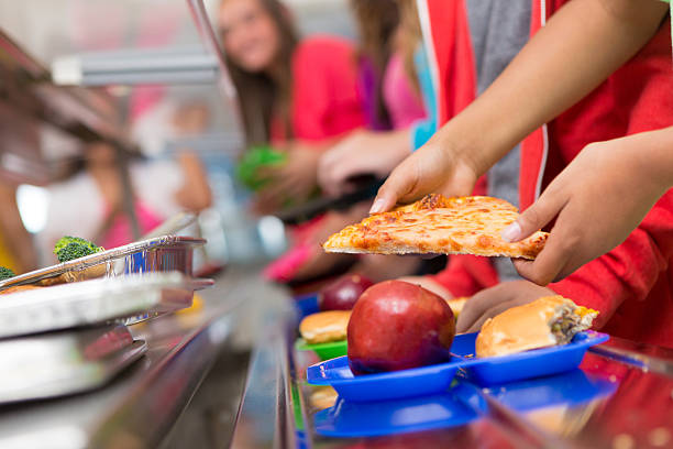 School children getting food in the cafeteria line School children getting food in the cafeteria line. school lunch stock pictures, royalty-free photos & images