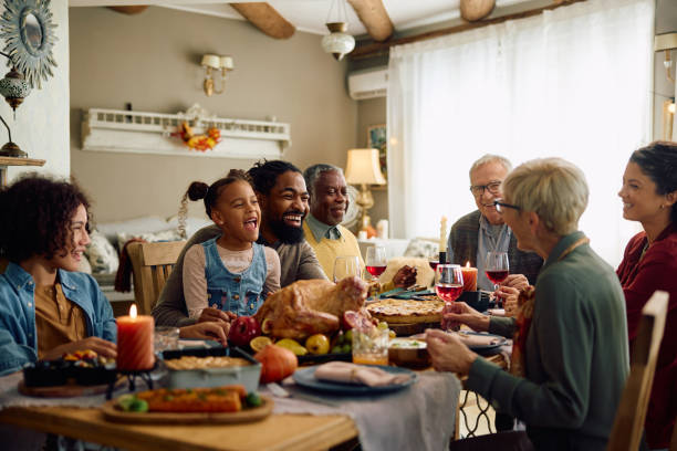 istock Happy extended family having fun while gathering at dining table on Thanksgiving. 1751784853